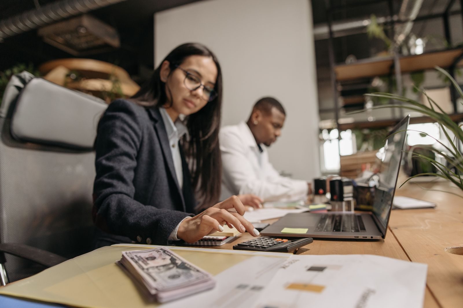 Accountant working through figures with a calculator at an office desk