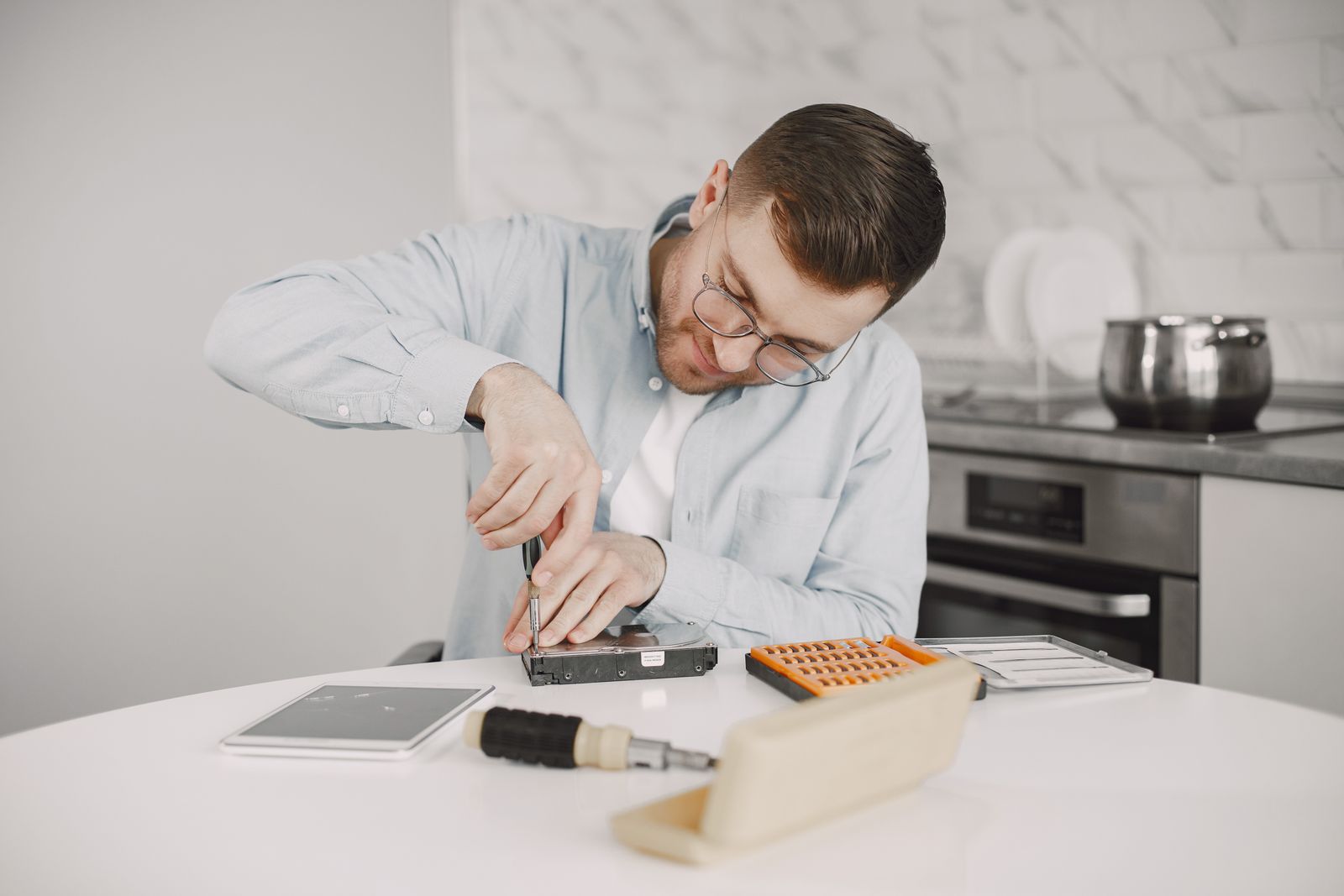 Technician repairing an appliance at a kitchen table