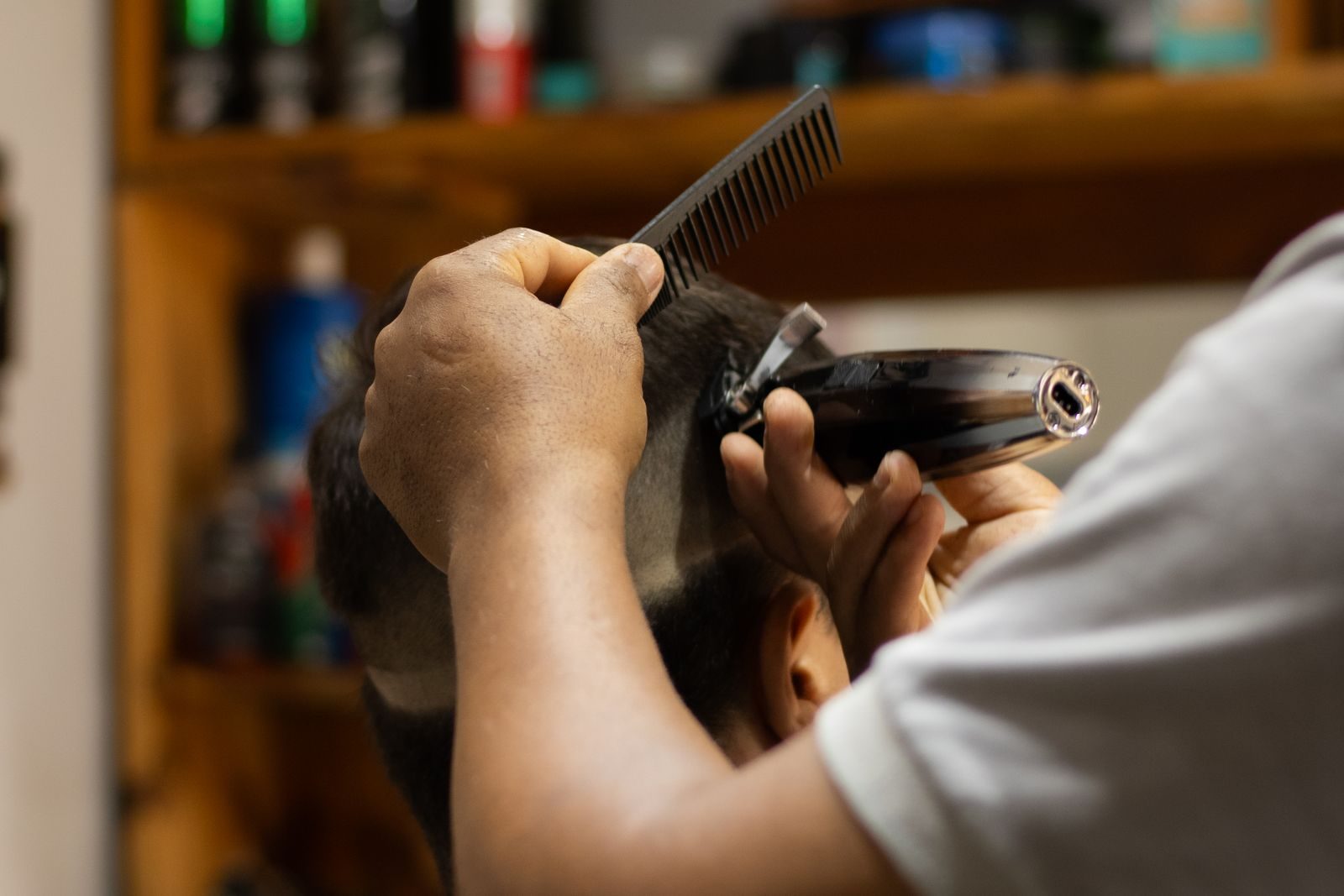 Barber cutting a client's hair in a barbershop chair