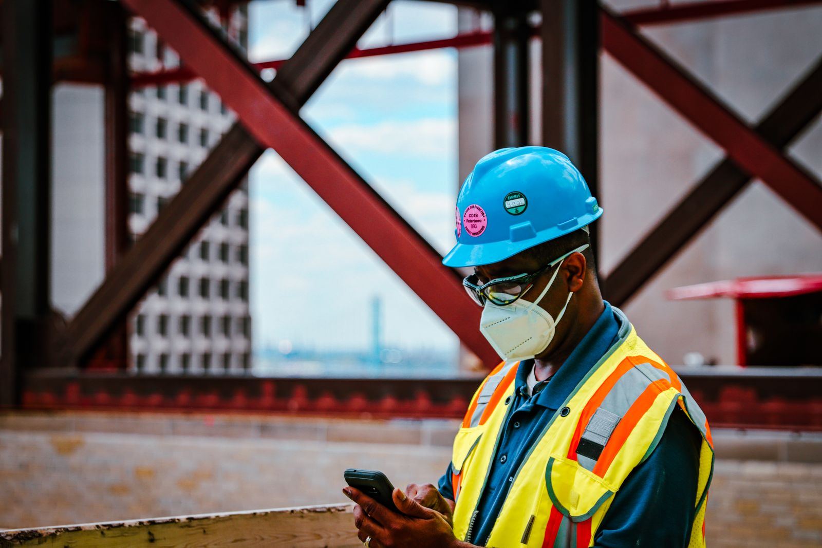 Construction worker checking a smartphone on site