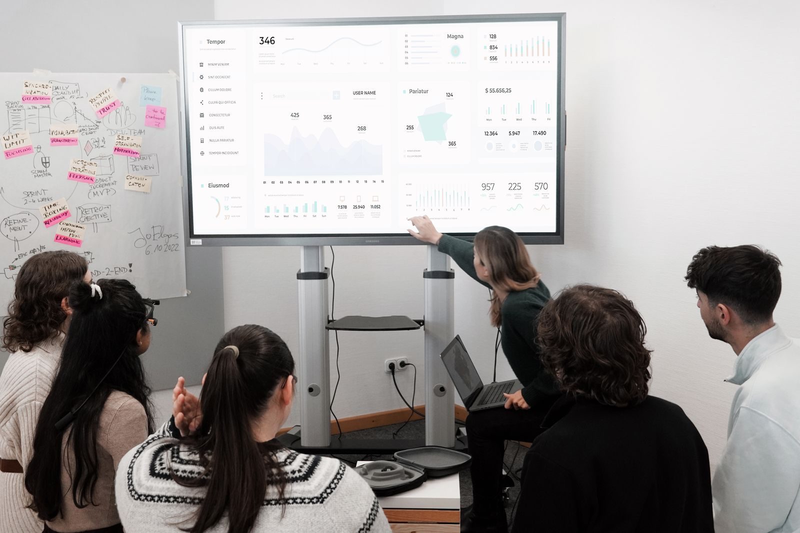 Team reviewing a campaign dashboard on a wall screen during a meeting