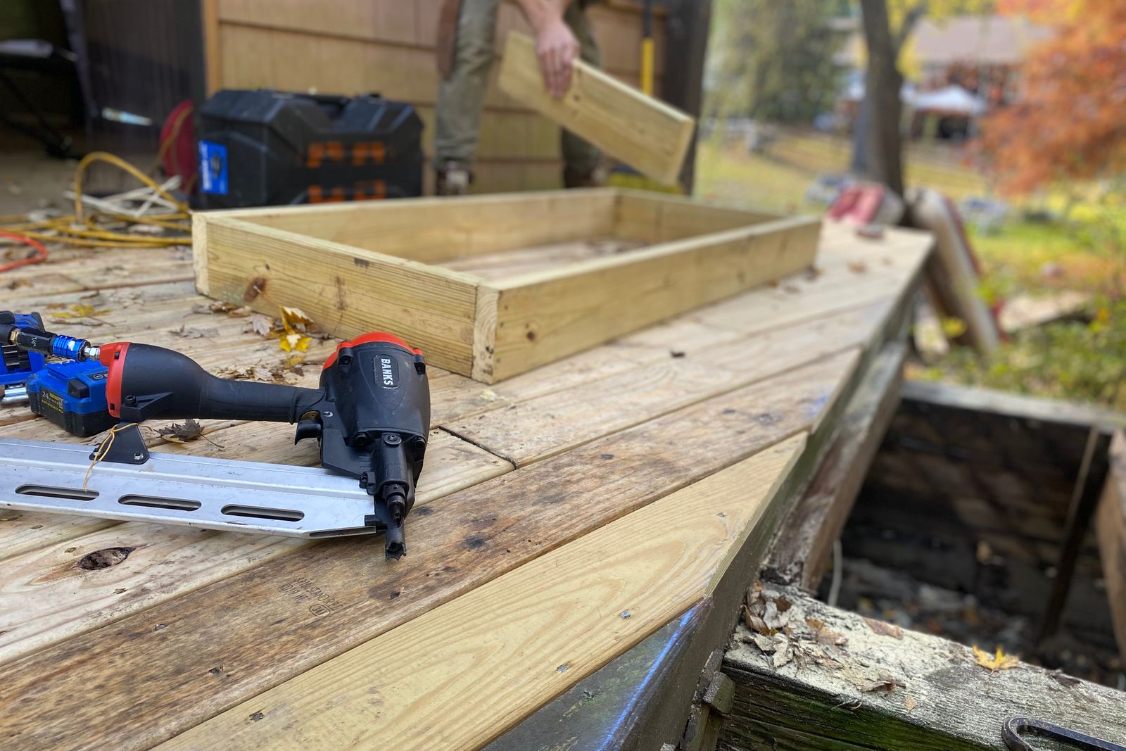 Deck framing in progress with a nail gun on the boards