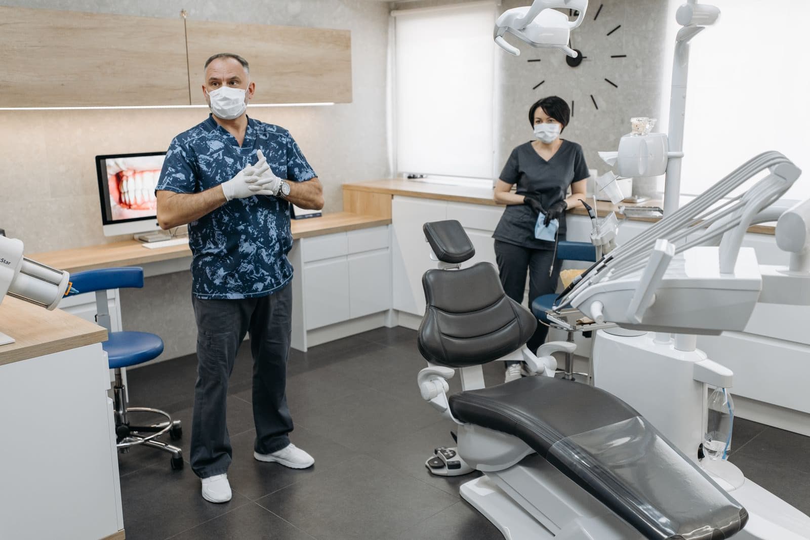 Dentist and assistant standing beside an empty chair in a modern dental operatory
