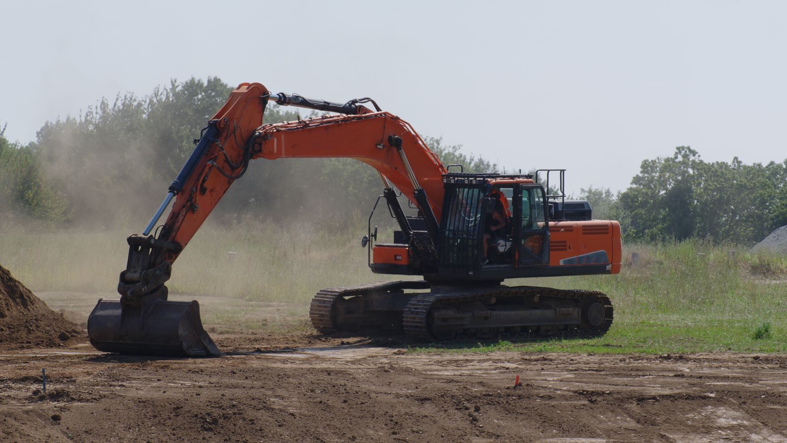 Excavator grading a cleared residential lot