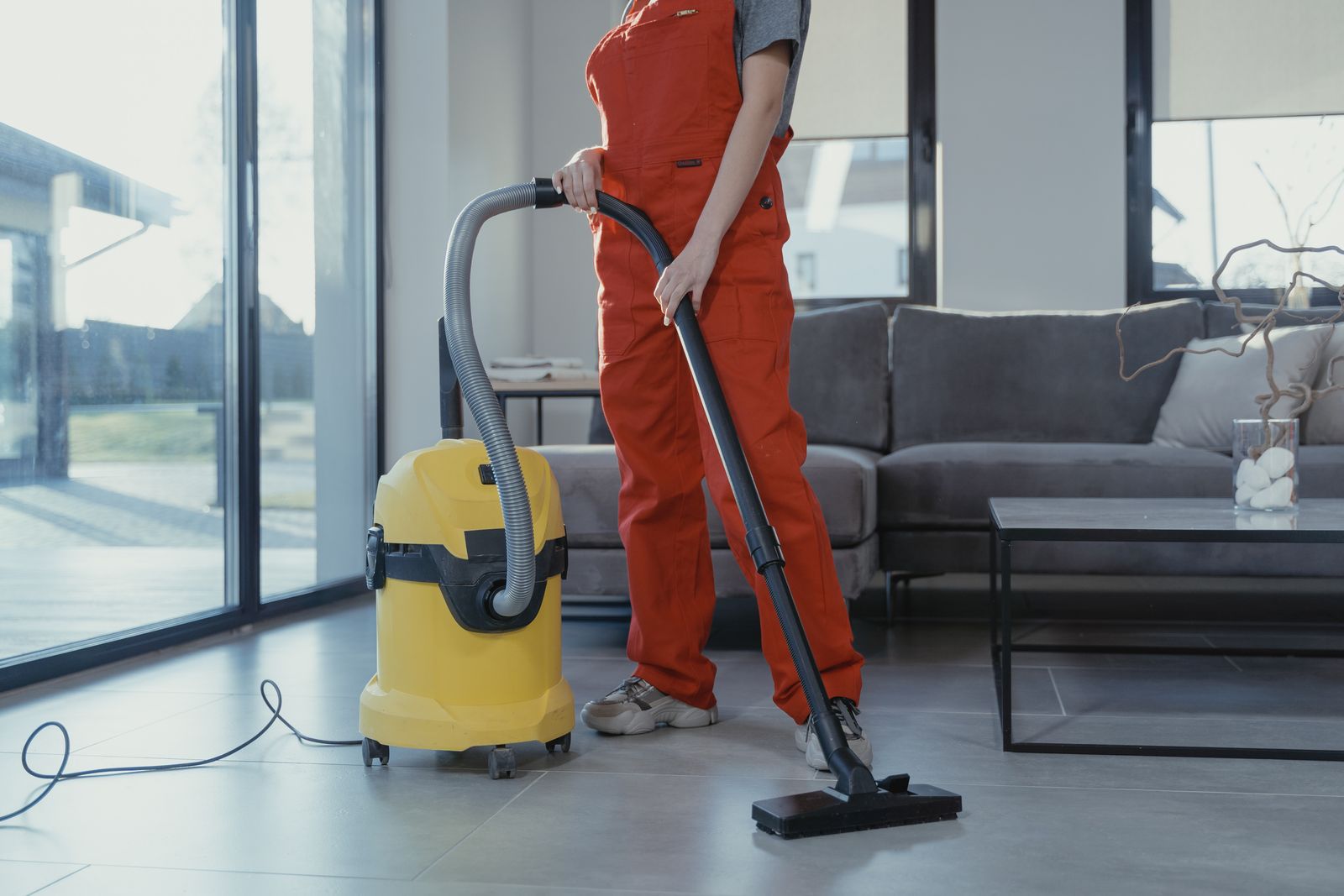 Professional cleaner vacuuming a living room
