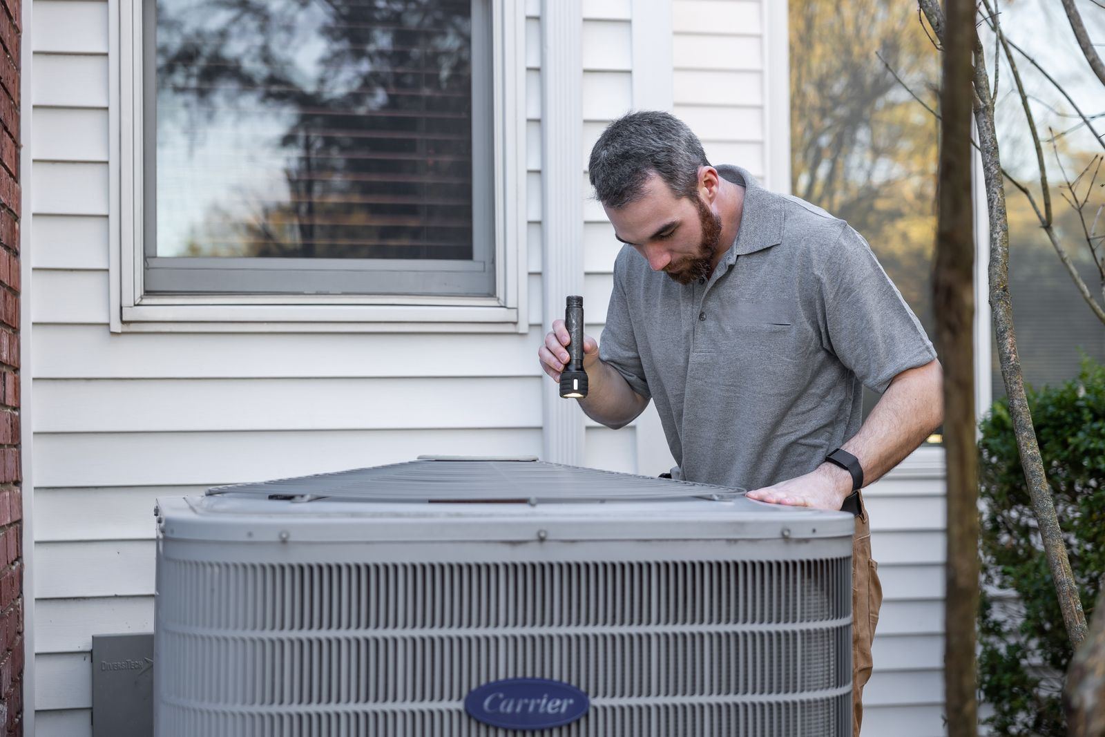 HVAC technician servicing an outdoor condenser unit