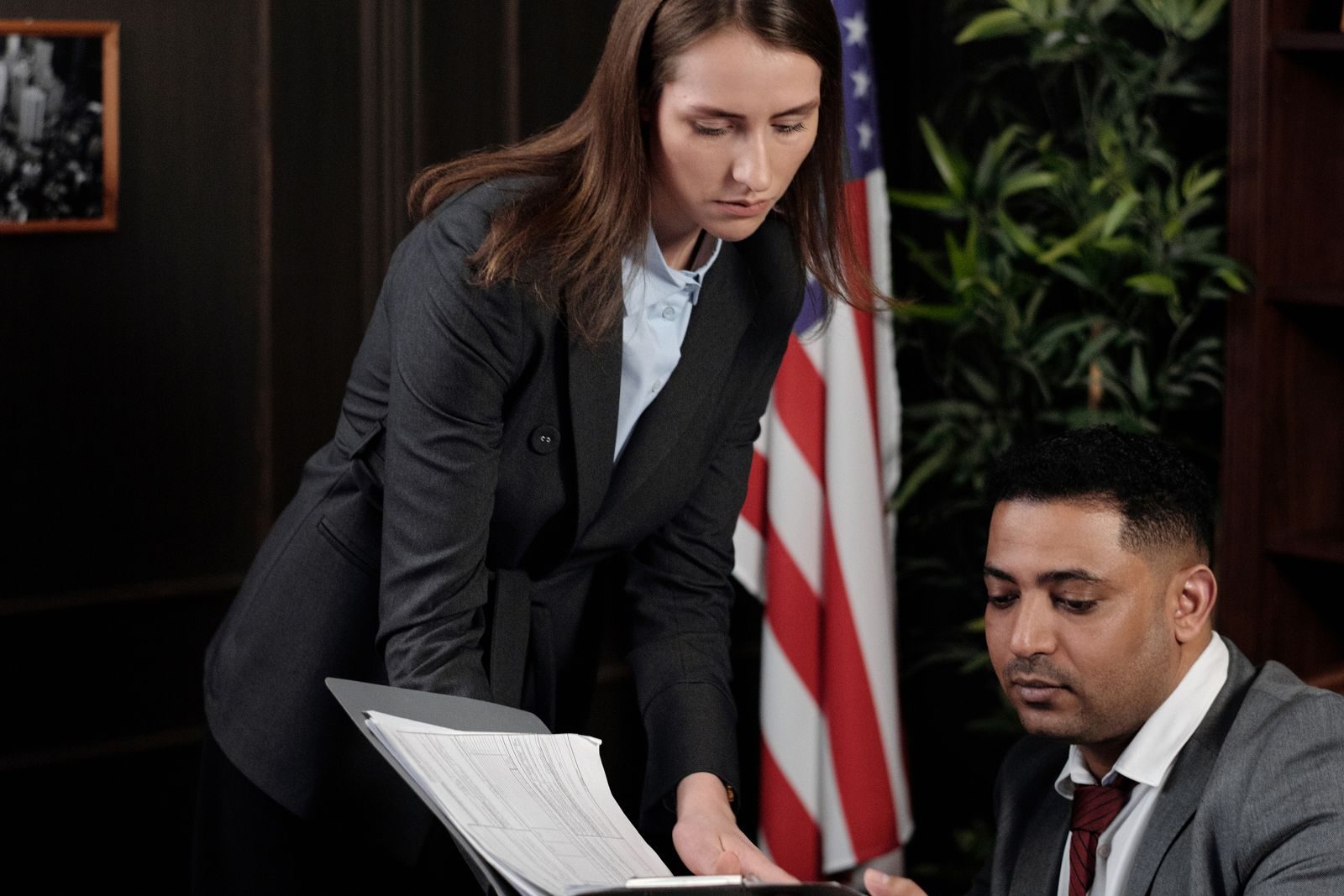 Immigration lawyer showing a client forms in a folder