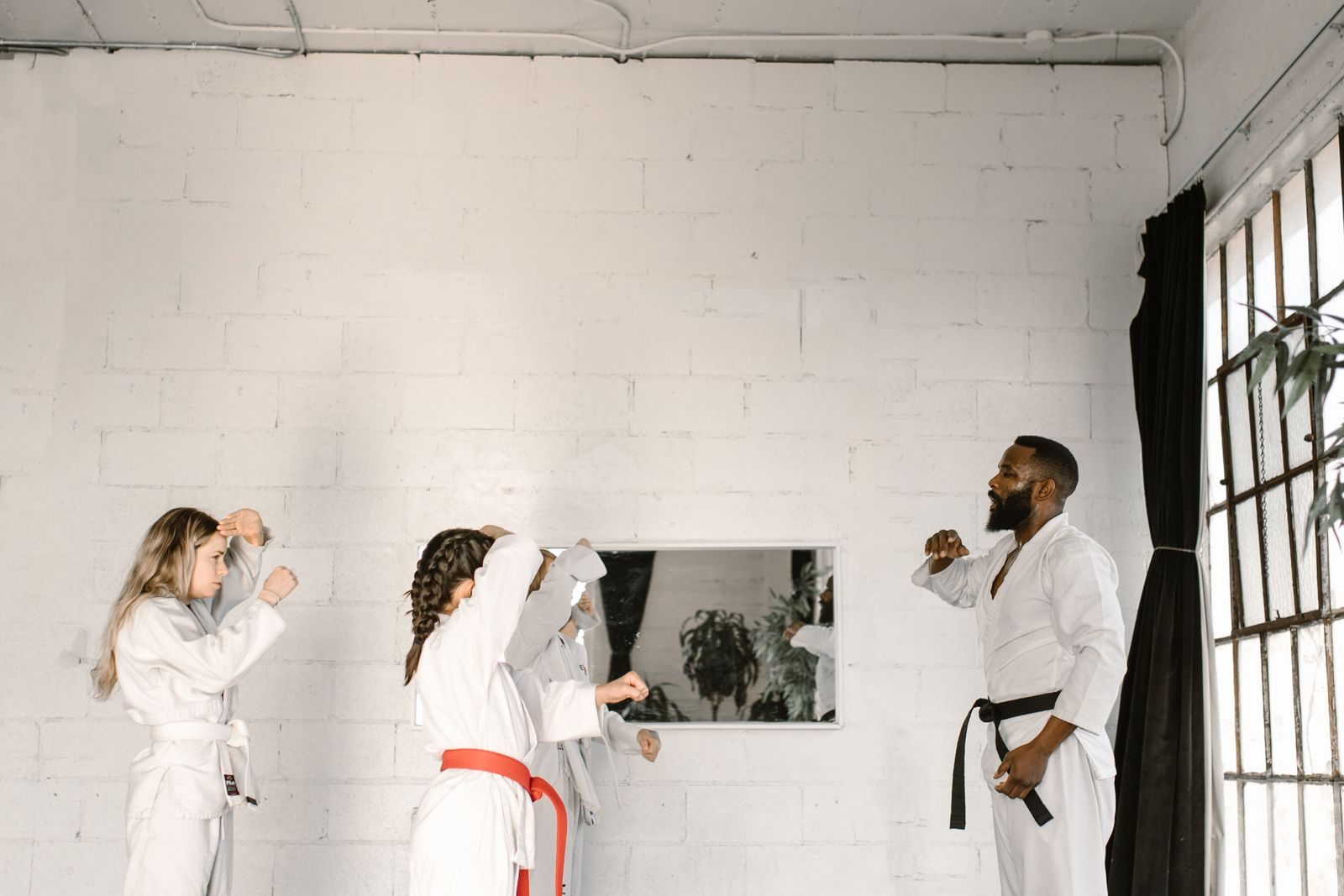 Martial arts class training on mats in a studio