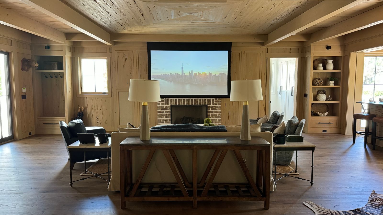 Living room with a projection screen lowered above the fireplace