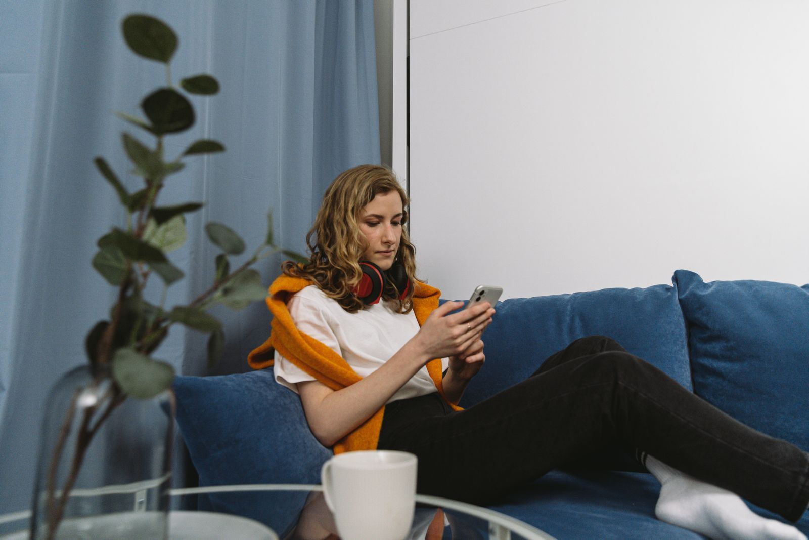 Homeowner scrolling a phone on a sofa at home
