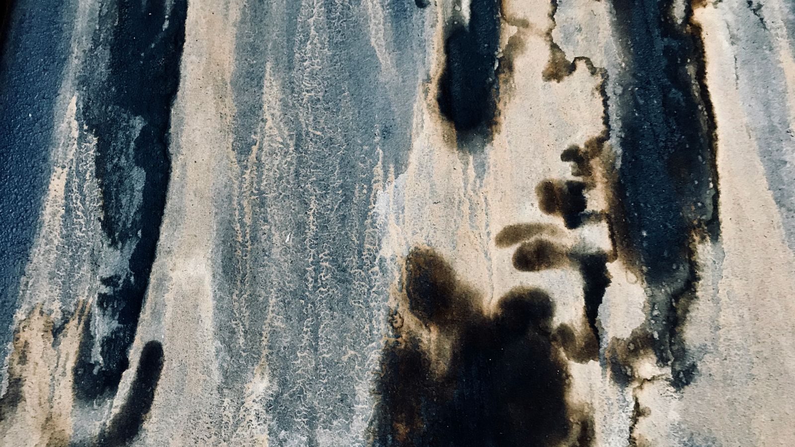 Black mildew staining spread across a damp interior wall