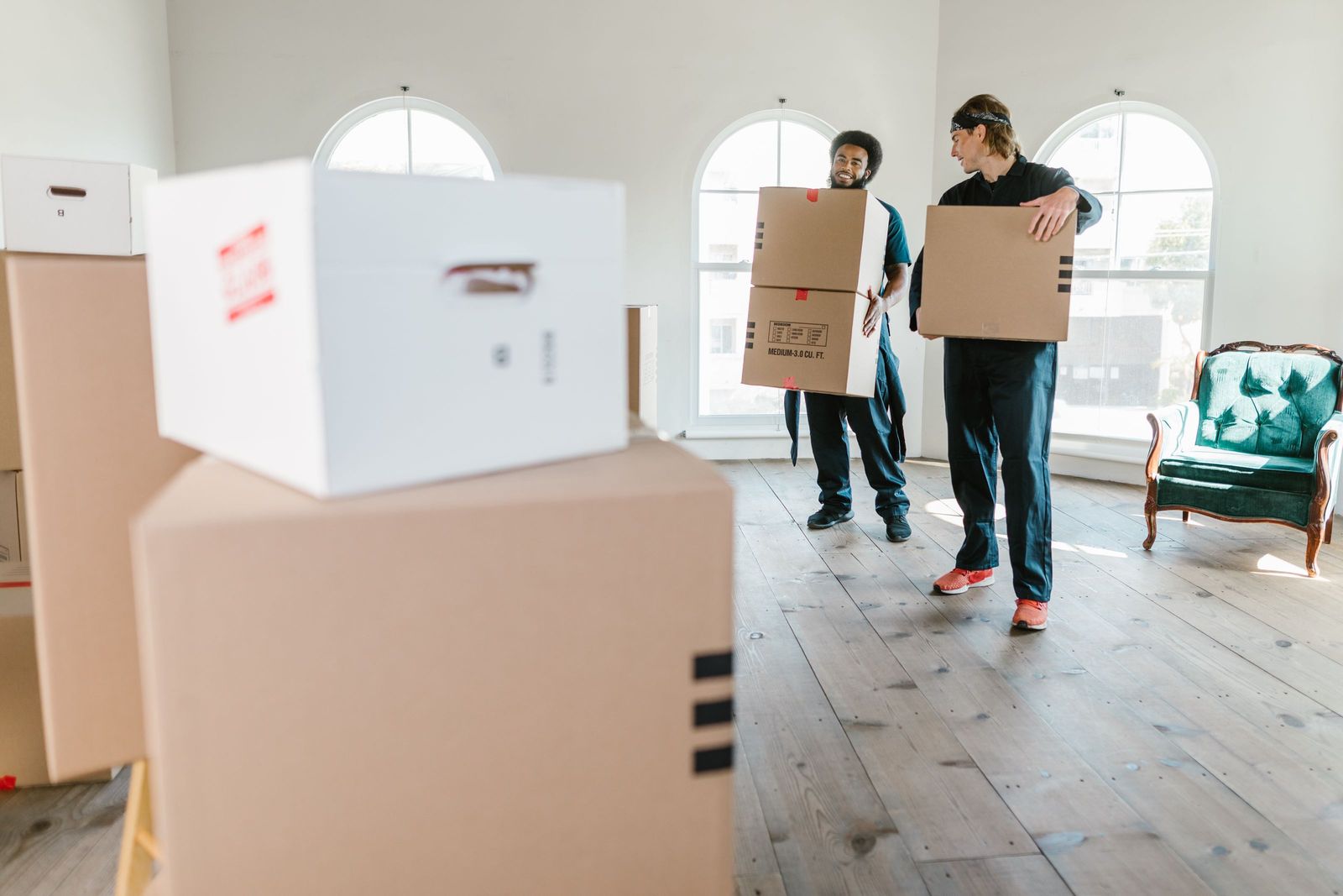 Movers carrying boxes from a truck into a home