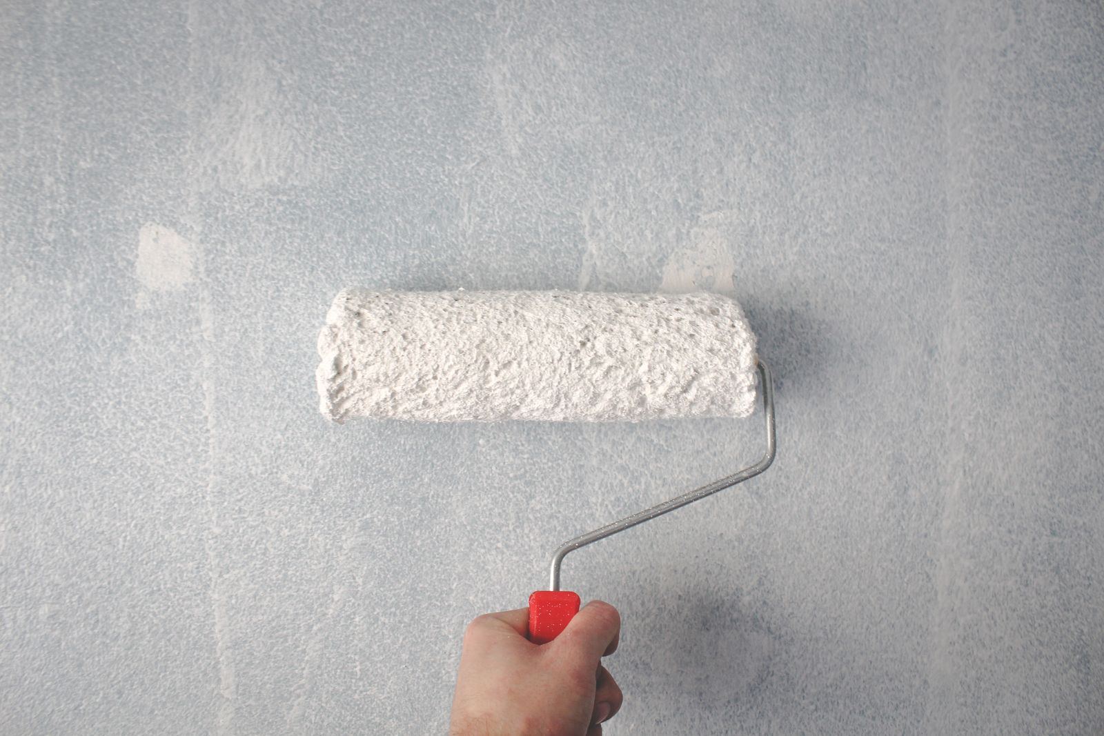 Paint roller applying a fresh coat to an interior wall