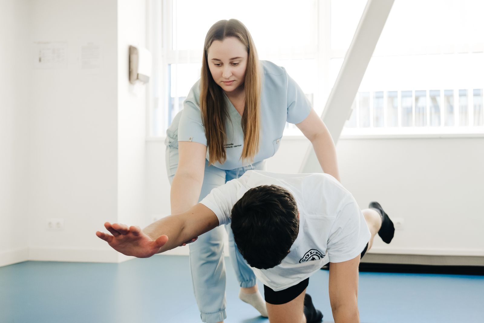 Physical therapist guiding a patient through a stretching exercise in a clinic