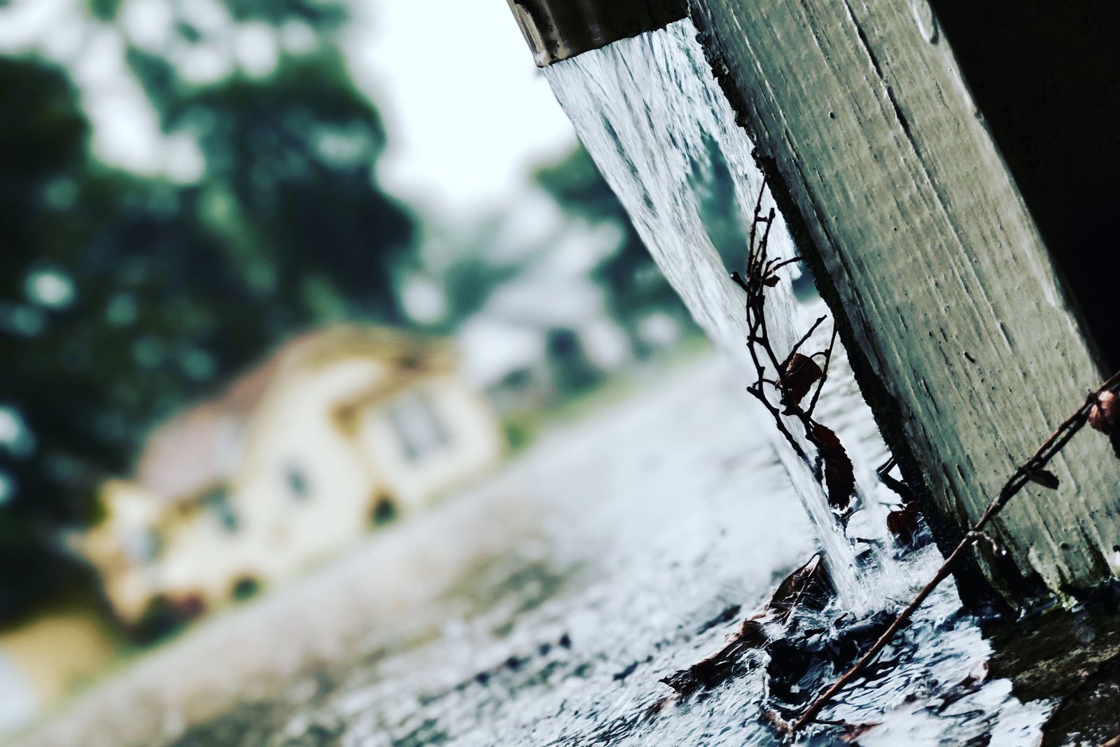 Rainwater pouring from a gutter during a storm