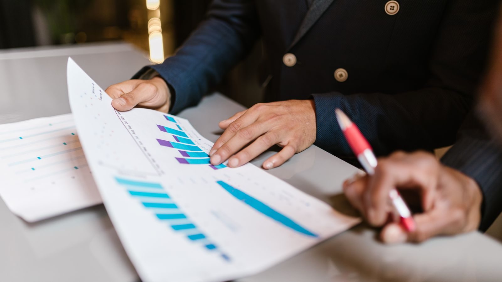 Hand marking a printed bar chart report with a pen during a review