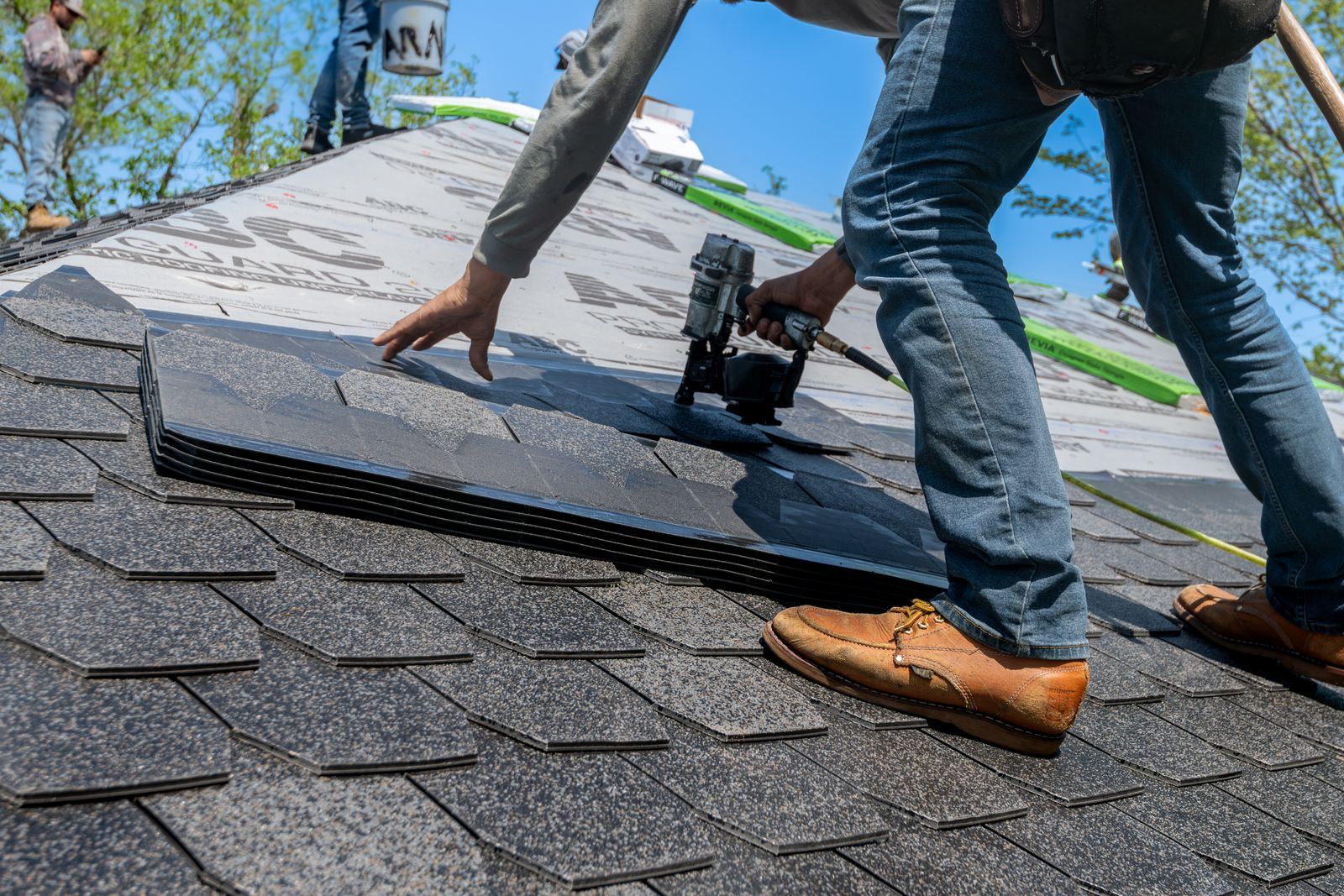 Roofer installing asphalt shingles on a residential roof