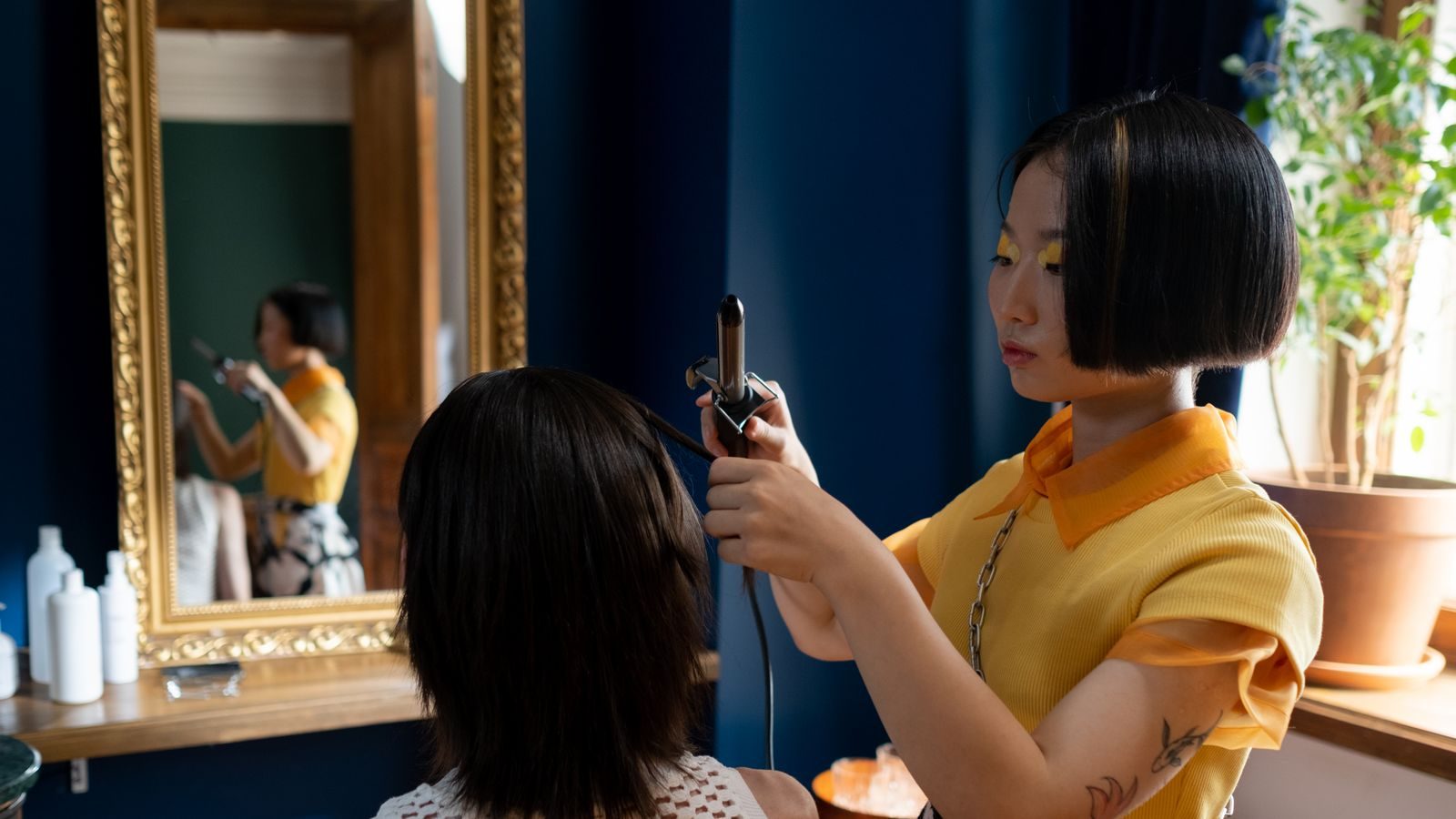 Stylist working on a client at a salon styling station