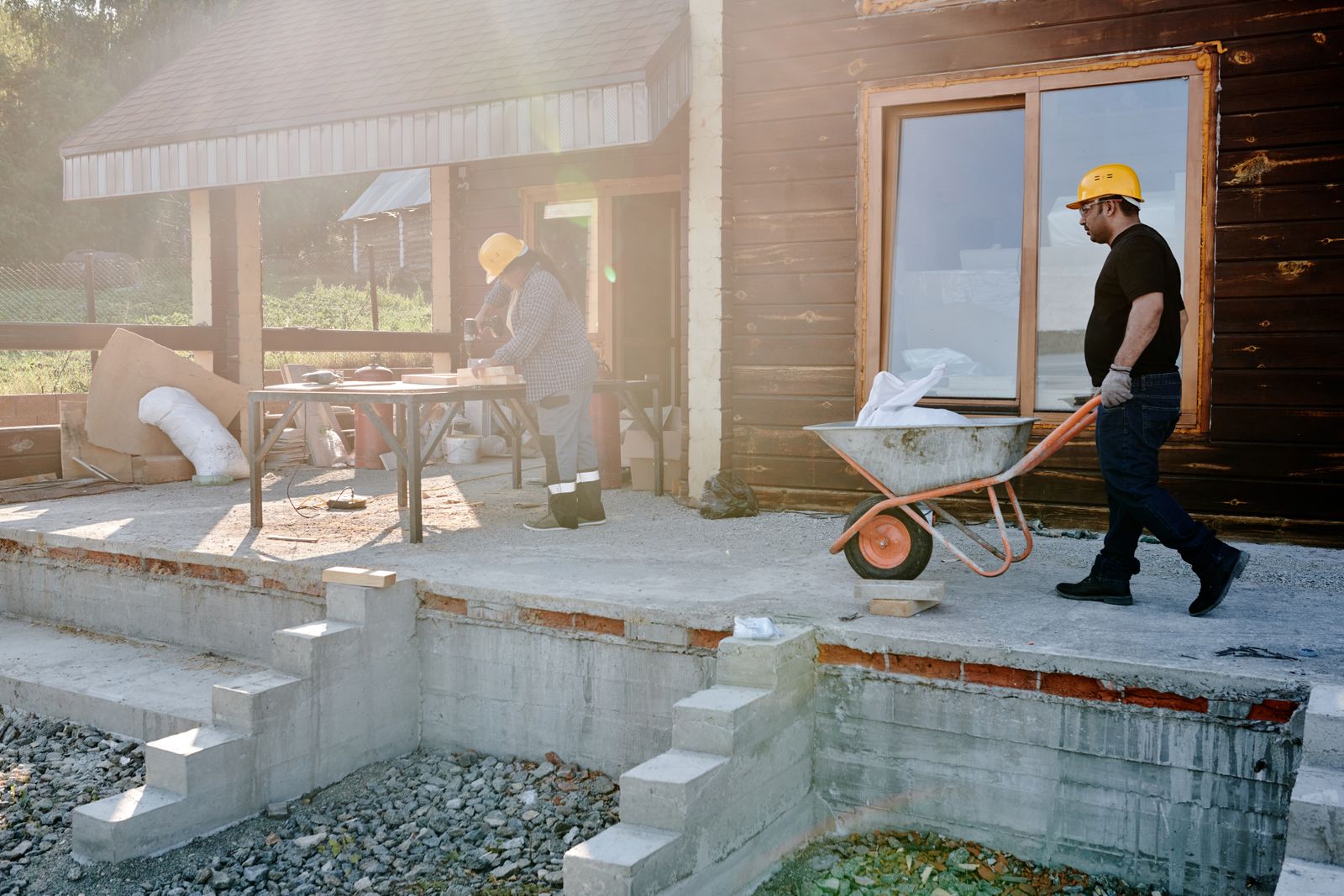 Two workers renovating the exterior of a house