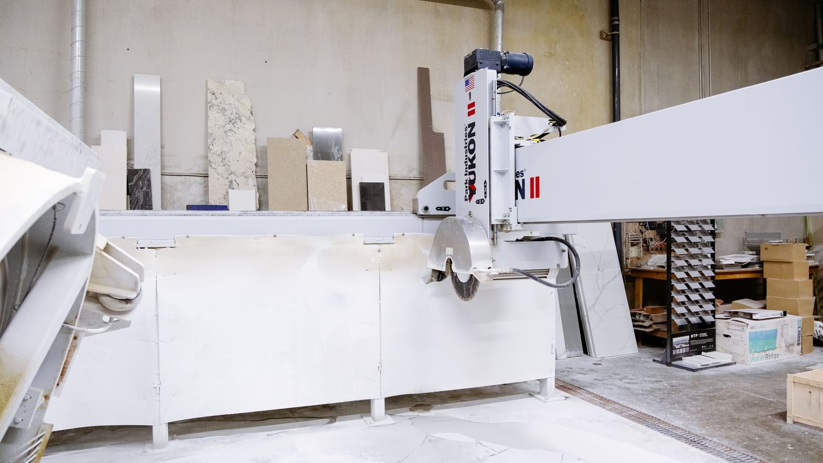 Bridge saw cutting a stone slab in a fabrication shop