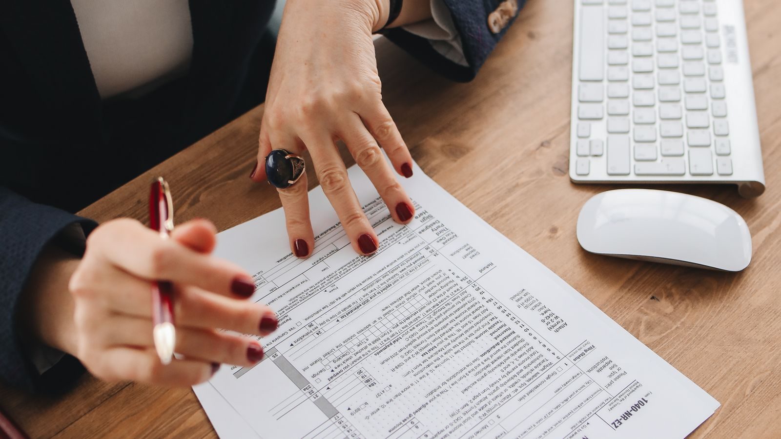Accountant reviewing a 1040 tax return form at a desk with a pen