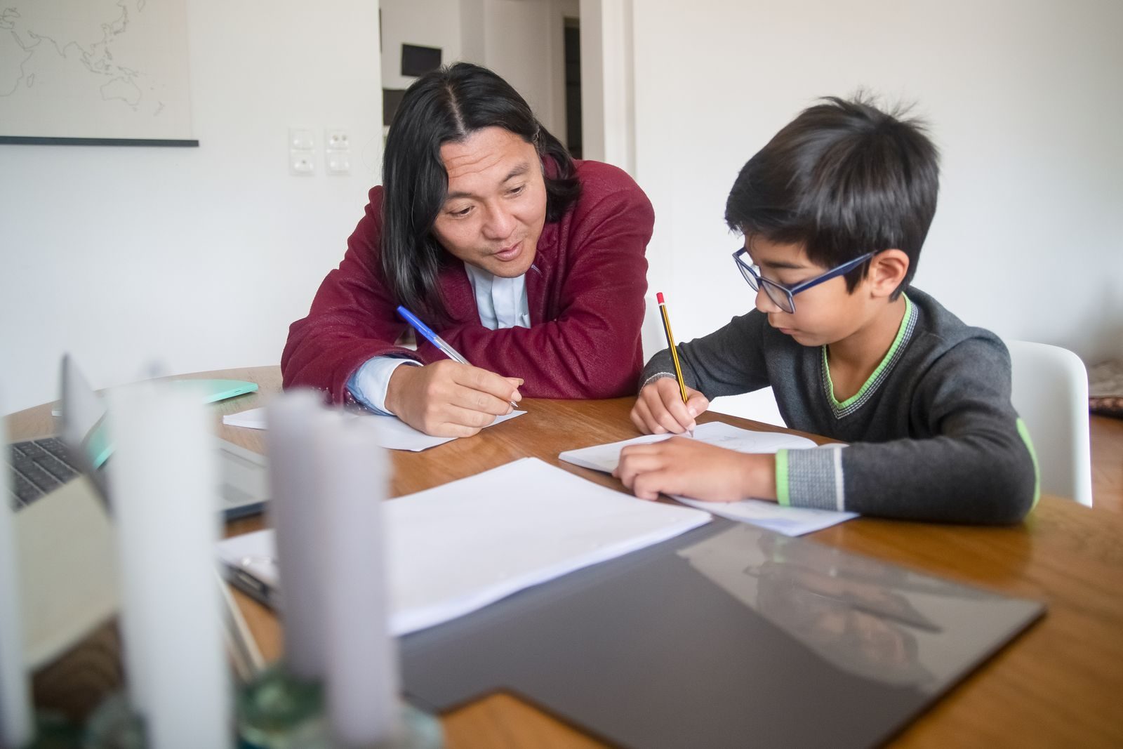 Tutor working through a math exercise with a boy at a table