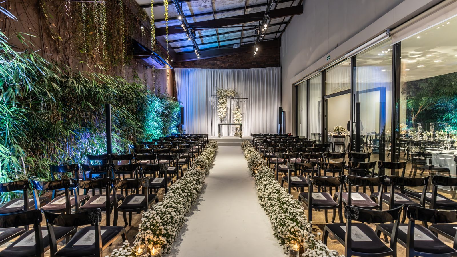 Indoor ceremony set up with rows of chairs and a flower-lined aisle