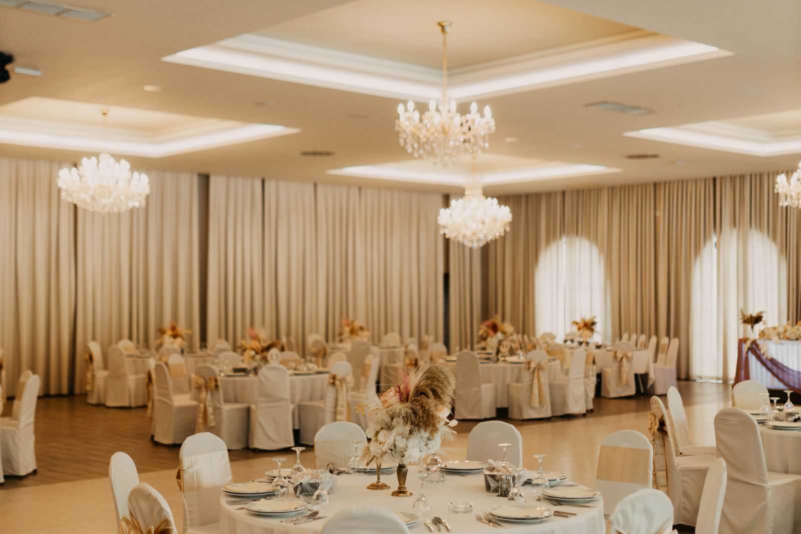 Wedding reception hall set with round tables, linens and lighting