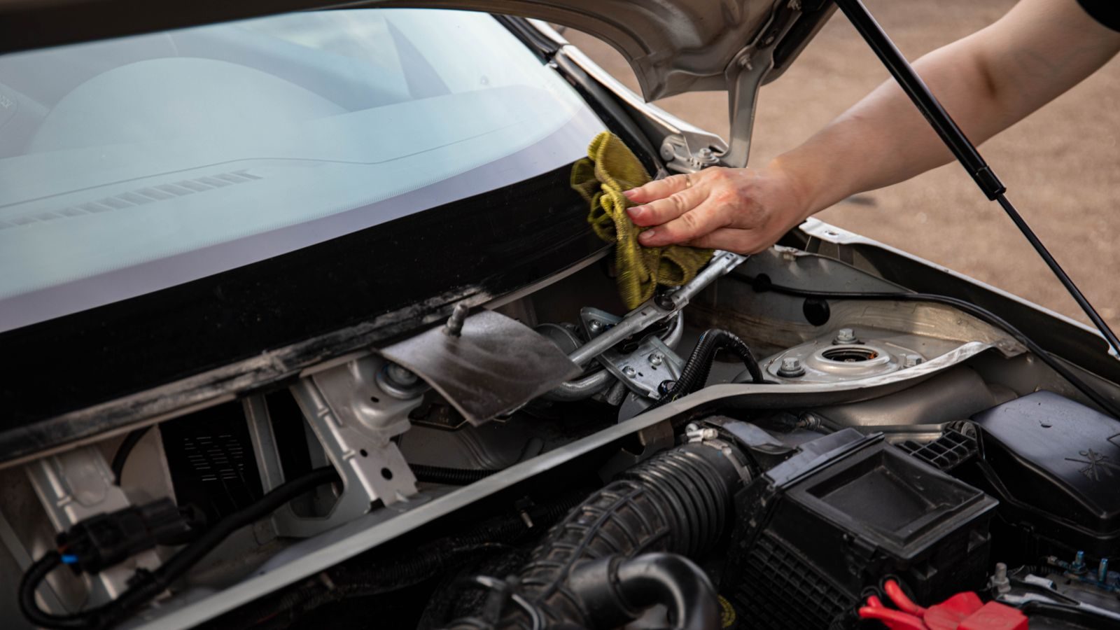 Technician cleaning a windshield in a workshop bay